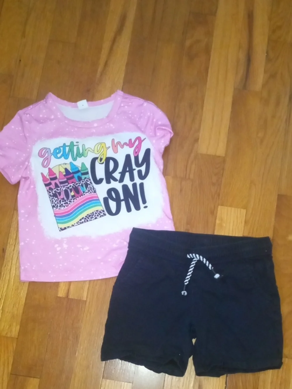 girl 4 black shorts and graphic pink tee